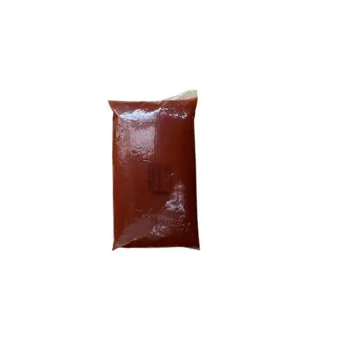Sealed plastic bag filled with red sauce or paste on a white background.
