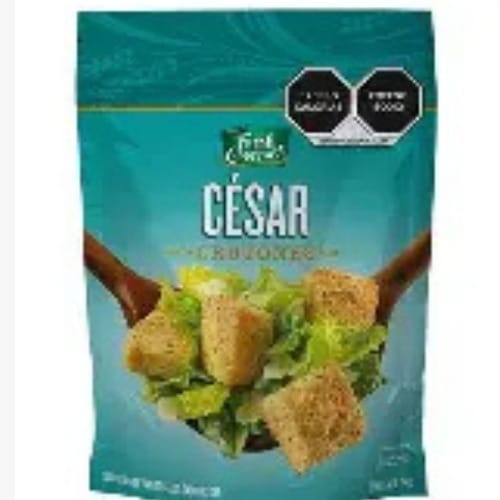 CRUTONES - Costa Rica Food Services l Food Services Teal bag of César Croutons with a bowl of croutons on a bed of salad displayed on the front.